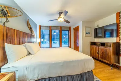 a bedroom with a large bed with a ceiling fan at Luxurious Remodeled Village Oasis in Mammoth Lakes