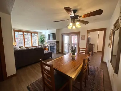 a living room with a wooden table and a ceiling fan at Quiet, Updated, Corner Condo in the Village! Parking, Pool & Spa in Mammoth Lakes