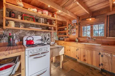 a kitchen with a white stove and wooden cabinets at Coziest Cabin in Tahoe w Stone Fireplace Comfy Beds Close to Slopes & Lake in Carnelian Bay