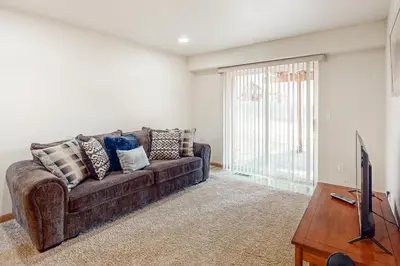 a living room with a brown couch and a tv at High Meadow Hideaway in South Lake Tahoe