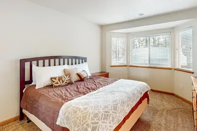 a bedroom with a large bed and two windows at High Meadow Hideaway in South Lake Tahoe