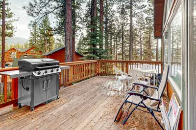 a screened in porch with a stove and a table and chairs at High Meadow Hideaway in South Lake Tahoe
