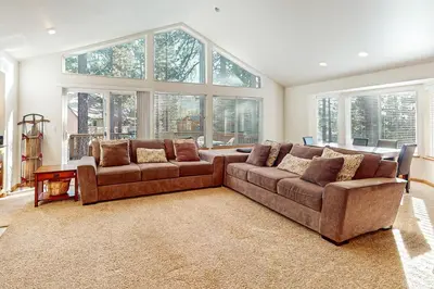 a living room with two brown couches and windows at High Meadow Hideaway in South Lake Tahoe