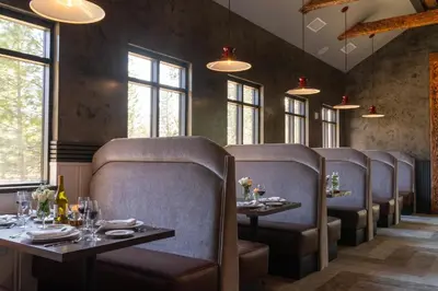a dining room with chairs and tables and windows at Firefall Ranch Yosemite in Groveland