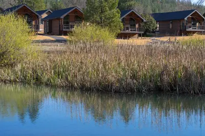 a row of lodges next to a body of water at Firefall Ranch Yosemite in Groveland