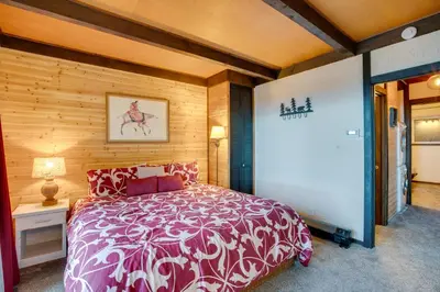 a bedroom with a bed and a wooden wall at 1 Mi to Stagecoach Lift! Homey Tahoe Townhome in Stateline