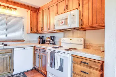 a kitchen with white appliances and wooden cabinets at Groveland Home with Deck 2 Mi to Pine Mountain Lake in Groveland