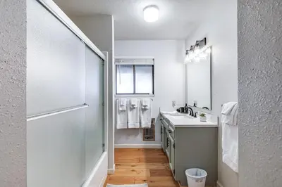 a white bathroom with a sink and a mirror at Groveland Home with Deck 2 Mi to Pine Mountain Lake in Groveland