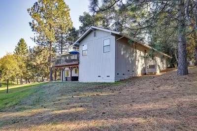 a white house on a hill with trees at Groveland Home with Deck 2 Mi to Pine Mountain Lake in Groveland