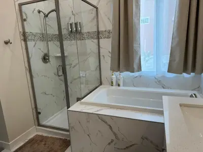 a bathroom with a shower and a tub and a sink at Brand New South Sacramento Home in Sacramento