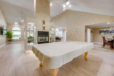 a large bedroom with a large bed and a living room at Billiards and Private Pool Bright Clovis Home! in Clovis