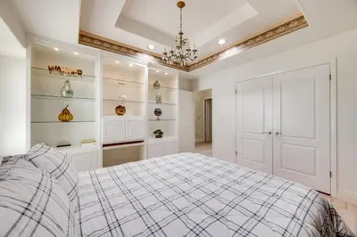 a white bedroom with a bed and a chandelier at Billiards and Private Pool Bright Clovis Home! in Clovis