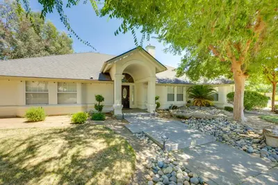 a home with a stone walkway in front of a house at Billiards and Private Pool Bright Clovis Home! in Clovis