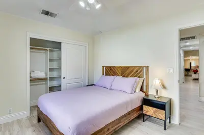 a bedroom with a large bed with purple pillows at Billiards and Private Pool Bright Clovis Home! in Clovis