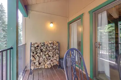 a stack of fire wood on the porch of a house at Strawberry Townhouse Walk to Leland Snowplay! in Strawberry