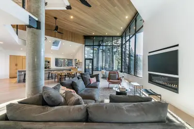a living room with a large couch and a tv at Open Air at Palisades - 3 BR, Brand New Construction - Wrap-Around Deck w Hot Tub in Olympic Valley