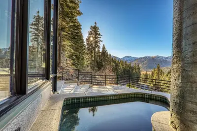 a pool in a house with a view of the mountains at Open Air at Palisades - 3 BR, Brand New Construction - Wrap-Around Deck w Hot Tub in Olympic Valley