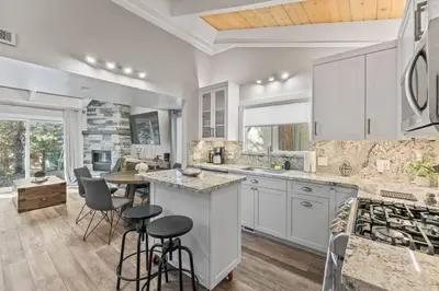 a kitchen with white cabinets and a table and chairs at Tahoe Bliss: Ski, Hike, & Relax in Incline Village