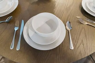 a wooden table with white plates and forks and spoons at Tahoe Bliss: Ski, Hike, & Relax in Incline Village