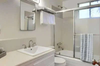 a white bathroom with a sink and a toilet at Blue Door Cottage 12 miles to Yosemite Bbq in Oakhurst