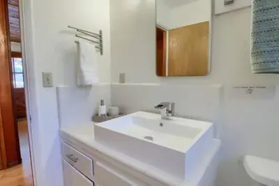 a white bathroom with a sink and a mirror at Red Door Cottage Fireplace bbq 12 mi to Yosemite in Oakhurst