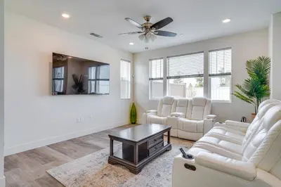 a living room with white furniture and a ceiling fan at Newly Built Tracy Home with Backyard and Pool Access! in Tracy