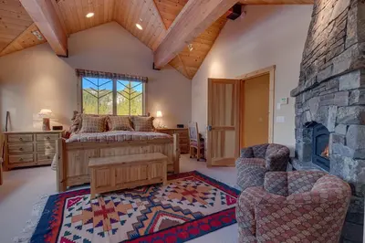 a bedroom with a large bed and a fireplace at Sundance Lodge -Mountain Home w Views of Palisades - Ski Shuttle, Pets okay! in Olympic Valley