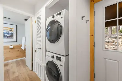 a laundry room with a washer and dryer next to a door at Carnelian Woods # 59 - 2 BR Carnelian Bay Retreat - Minutes to Lake w HOA Amenities in Carnelian Bay