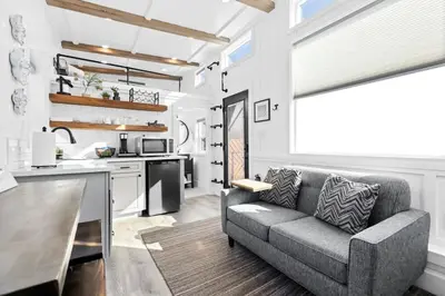 a living room with a couch and a kitchen at Tiny Home | Lewis Ranch 1 in Lindsay