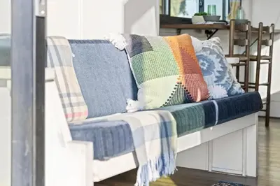 a couch with pillows on it with a blanket at Tiny Cargo Home South in Tulare