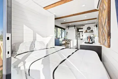 a bedroom with a large white bed in a room at Tiny Cargo Home South in Tulare
