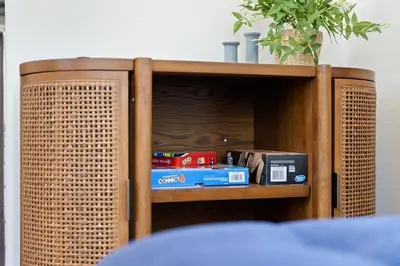 a wooden cabinet with books and other items on it at Tiny River House in Three Rivers