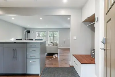 a kitchen with white cabinets and a living room at Luxurious 2BD Smart Home Near Beach in Tahoe City