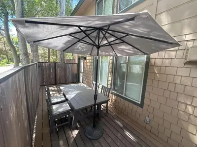 an umbrella on a deck with a table and chairs at Luxurious 2BD Smart Home Near Beach in Tahoe City