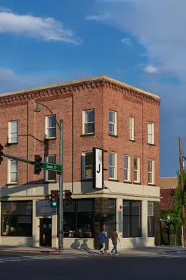 two people crossing a street in front of a brick building at The Jesse Hotel & Bar in Reno