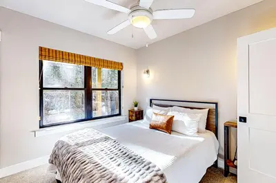 a bedroom with a bed with a ceiling fan and a window at Twilight's Rest in Zephyr Cove