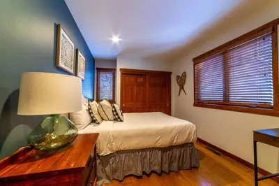 a bedroom with a bed and a table with a lamp at Luxury Townhome, Walk to the Village, Wifi, Private Spa & Garage in Mammoth Lakes