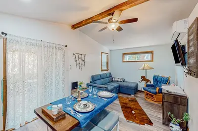 a living room with a blue couch and a tv at 1BR Dog-Friendly Lakefront Cabin with Canoes in Twain Harte