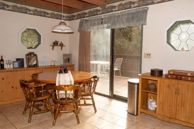a kitchen and dining room with a wooden table and chairs at A-Frame Cabin in The Sequoias in Wofford Heights