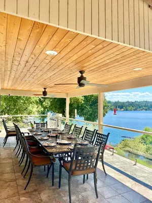 a table and chairs on a patio with a view of the water at Luxury Yosemite Lake House in Groveland