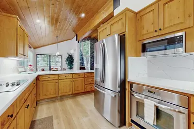 a kitchen with wooden cabinets and stainless steel appliances at Gold Bear in Truckee