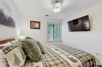 a bedroom with a bed and a flat screen tv at Gold Bear in Truckee