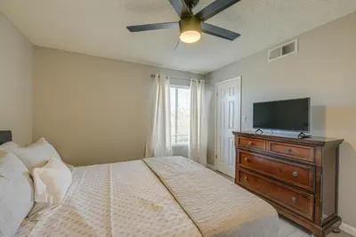 a bedroom with a bed and a flat screen tv at Cozy Fresno Condo with Balcony and Pool Access in Fresno