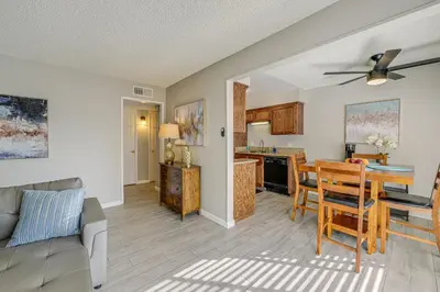 a living room with a table and a kitchen at Cozy Fresno Condo with Balcony and Pool Access in Fresno
