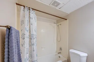 a bathroom with a shower curtain and a toilet at Cozy Fresno Condo with Balcony and Pool Access in Fresno