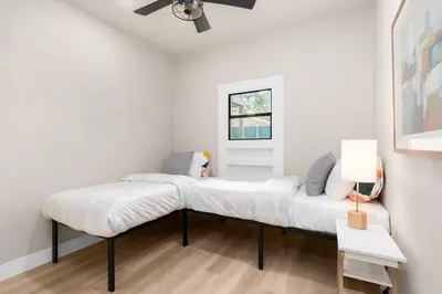 two beds in a room with white walls at Downtown Lodi l Renovated l 5 Bedrooms l Sleeps 10 in Lodi