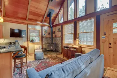 a living room with a blue couch and a fireplace at Less Than 1 Mi to Beach Peaceful Studio with Deck in Tahoma in Tahoma