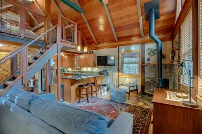 a living room with a blue couch in a house at Less Than 1 Mi to Beach Peaceful Studio with Deck in Tahoma in Tahoma