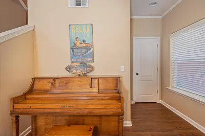 a wooden piano in a room with a picture on the wall at Yosemite Bass Lake Adventure Oasis in Bass Lake