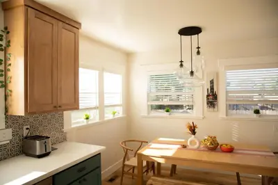 a kitchen with a table and two windows at Reno's Biggest Little House - Cozy Home Theatre in Reno